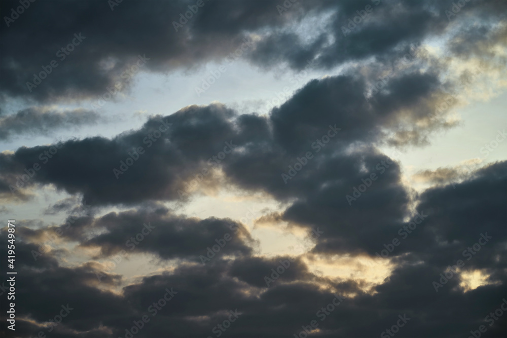  clouds and natural purple-orange lighting from the evening dawn. picturesque artistic backdrop for atmospheric design. dramatic evening cloudscape. telephoto of cumulus clouds
