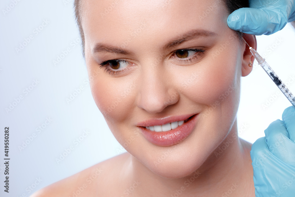 Beautiful woman with short hair gets a beauty injection in her face Beautiful woman with short hair gets a beauty injection in her face