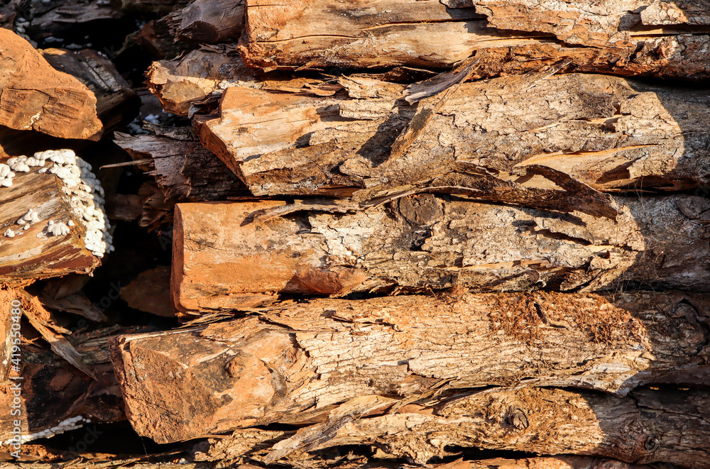 A pile of stacked firewood. Natural wooden background. A pile of stacked firewood. Natural wooden background.