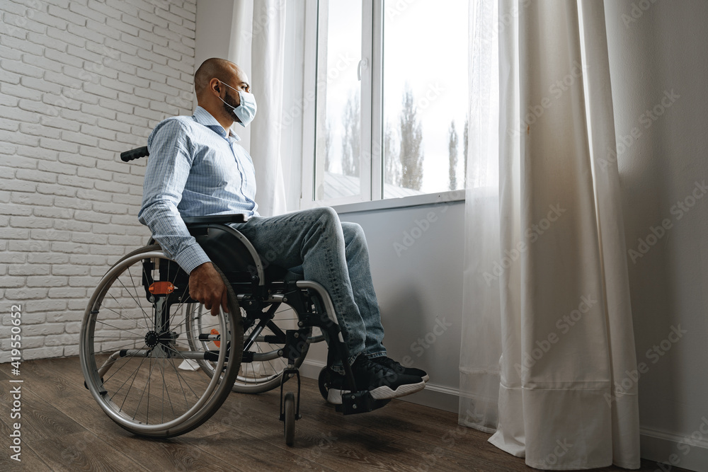 Disabled man sitting in a wheelchair and wearing face mask Disabled man sitting in a wheelchair and wearing face mask