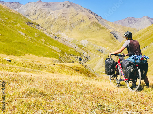 Back view cyclist push touring bicycle uphill to mountain. Atsunta pass trekking route on bicycle