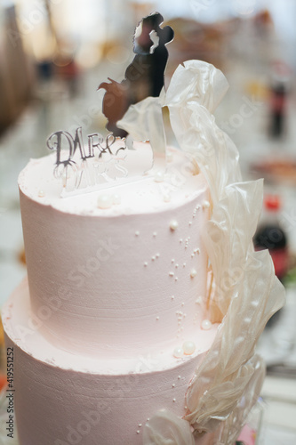 Wedding cake. Confectionery art. Three-tiered wedding cake.Cake with fresh flowers. Cake with lighting. Candy bar.