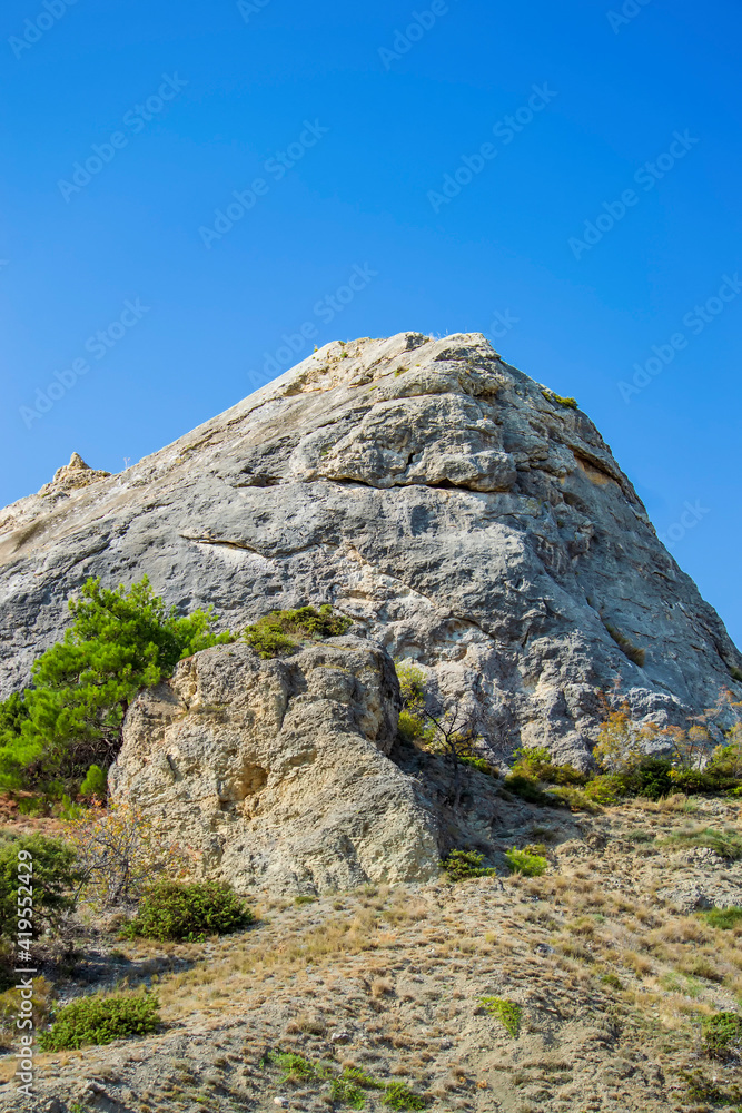 Rock and vegetation are scarce in Crimea against clouds and sky. Rock and vegetation are scarce in Crimea against clouds and sky.