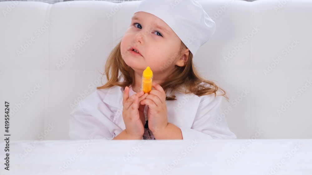 little girl plays a doctor, makes an injection. Corona virus treatment concept, injection during pandemic little girl plays a doctor, makes an injection. Corona virus treatment concept, injection during pandemic