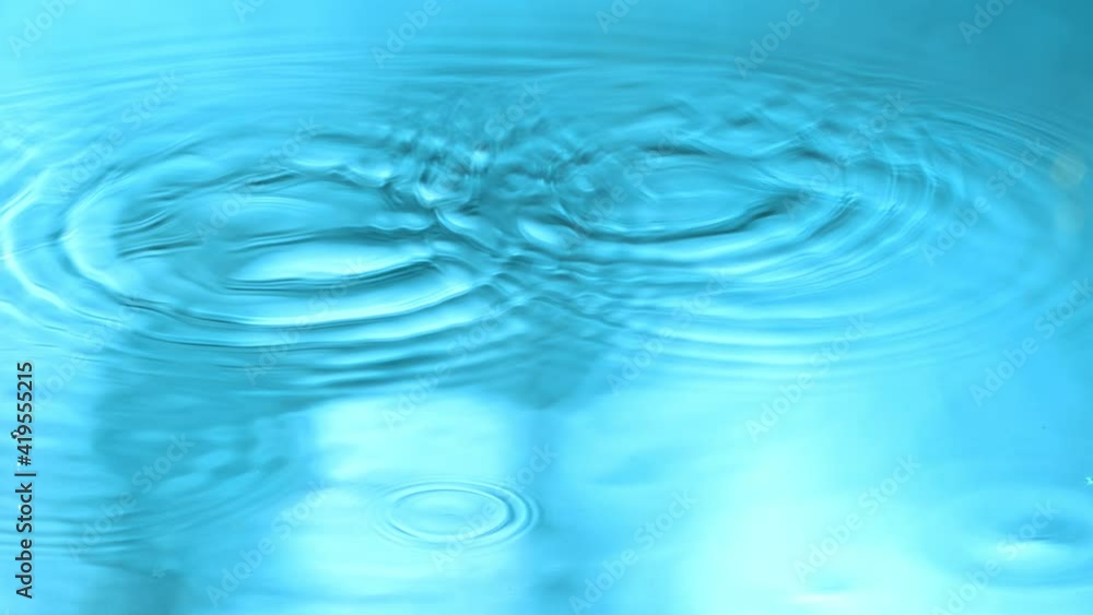 Super Slow Motion Detail Shot of Water Drop on Blue Gradient Background at 1000 fps. Super Slow Motion Detail Shot of Water Drop on Blue Gradient Background at 1000 fps.