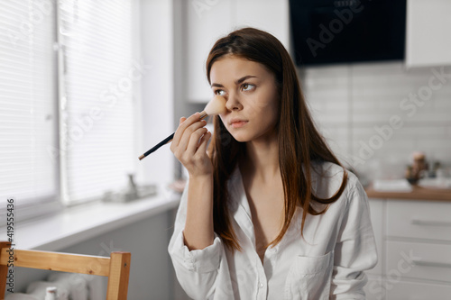 woman with makeup brush foundation on face  © SHOTPRIME STUDIO