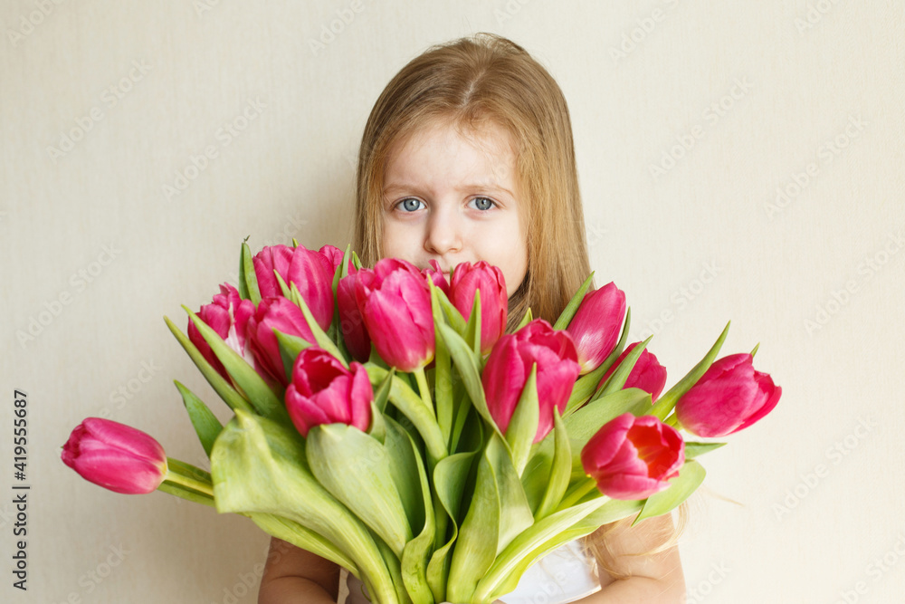 portrait of litlle girl with bouquet of flowers tulips in her hands