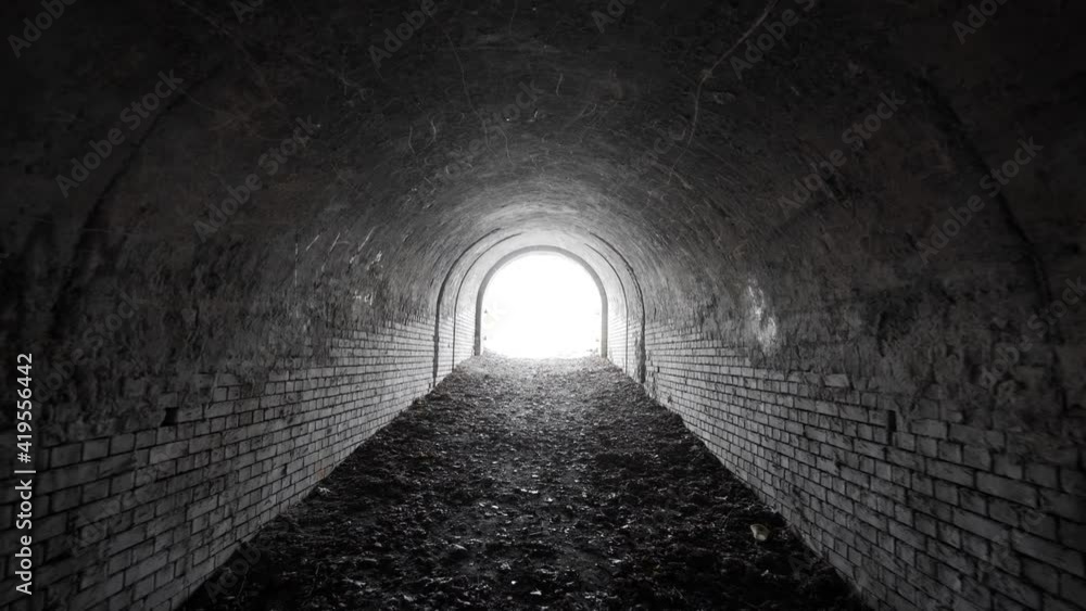 Exit from the old abandoned brick arch tunnel of the 19th century fortification with light in the end. Dolling view. Exit from the old abandoned brick arch tunnel of the 19th century fortification with light in the end. Dolling view.