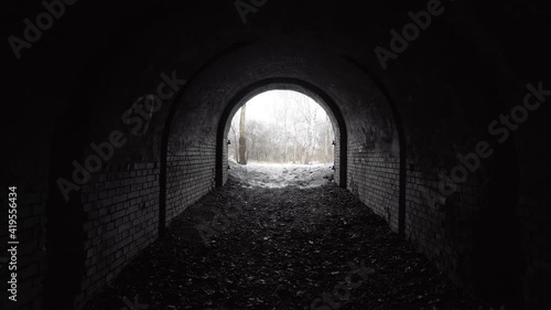 Exit from the old abandoned brick arch tunnel of the 19th century fortification in the woods. Dolling view. photo