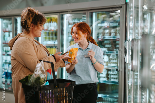 Assistant helping customer at supermarket