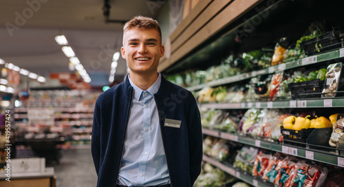 Portrait of young worker in supermarket photo