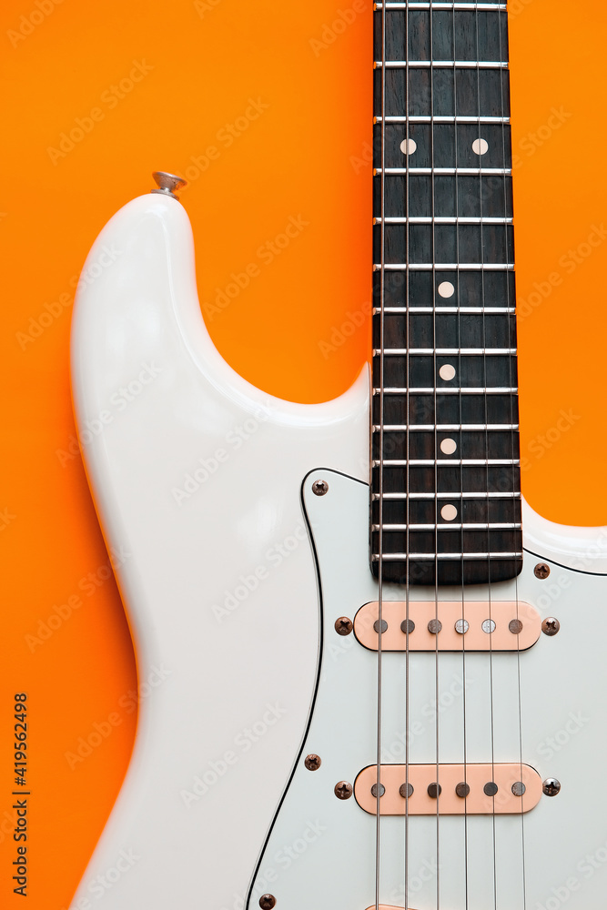 Fototapeta premium Detail of White Electric Guitar on a orange background.