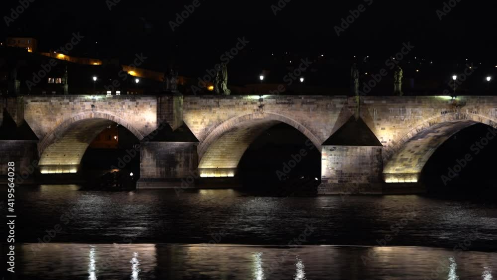 .illuminated pillars of Charles Bridge on the flowing Vltava river in the center of Prague at night, timelapse .illuminated pillars of Charles Bridge on the flowing Vltava river in the center of Prague at night, timelapse
