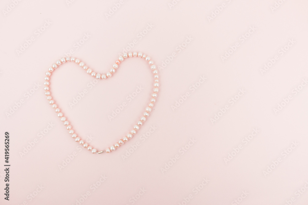 Banner with a pearl heart on a light pink background. Space for text