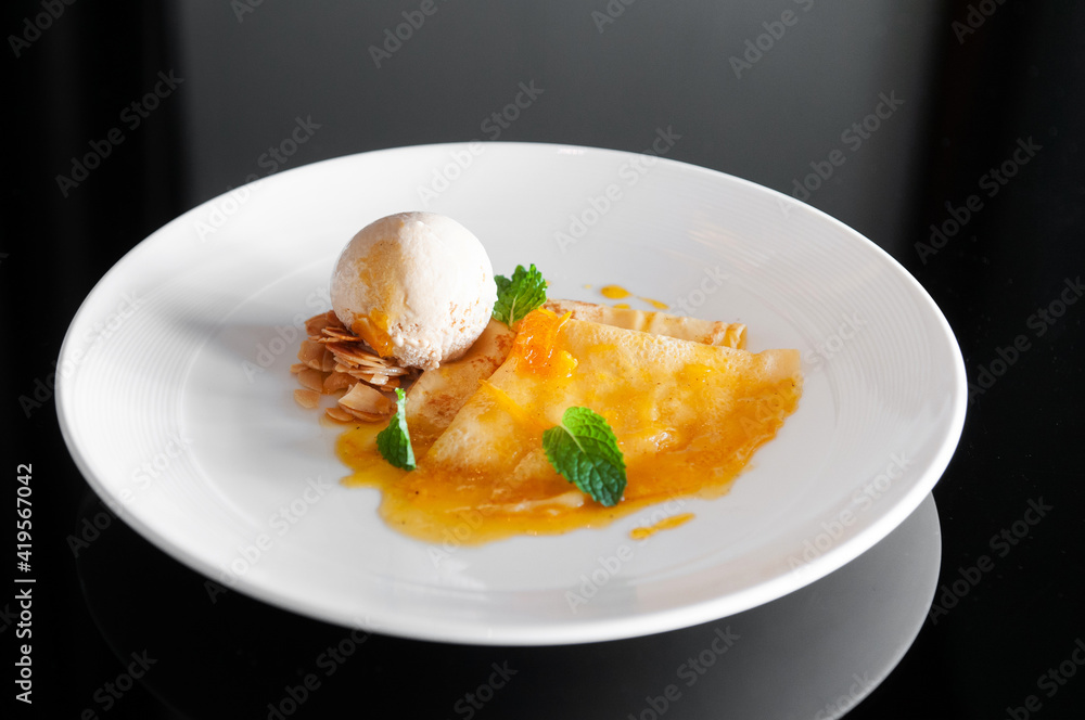 French crepe with fresh sweet orange sauce and ice cream. Top view French crepe with fresh sweet orange sauce and ice cream. Top view