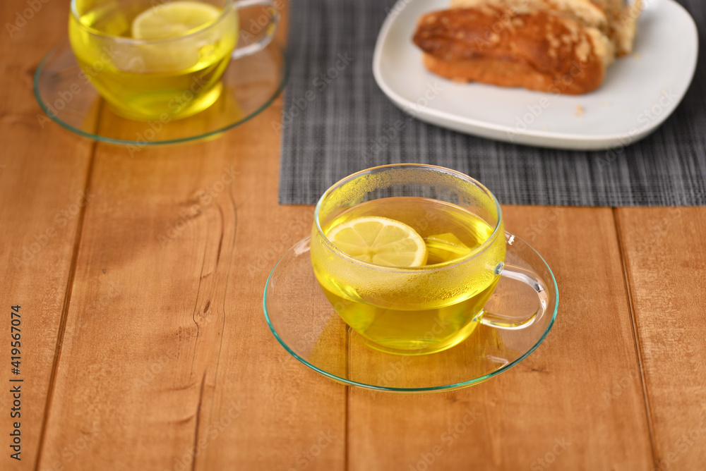 Lemon tea in a glass cup on the wooden table. Lemon tea in a glass cup on the wooden table.