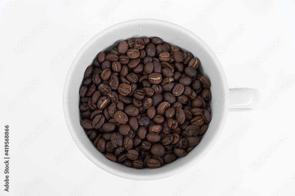 Coffee beans in a white mug on a white background Coffee beans in a white mug on a white background
