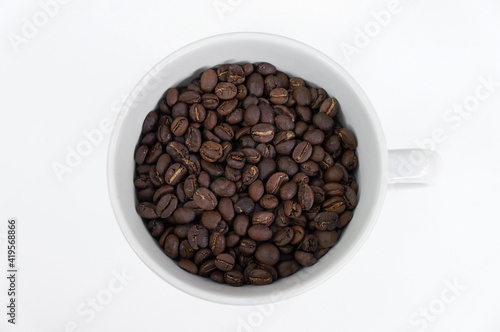 Coffee beans in a white mug on a white background