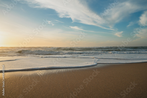 Empty sand beach at sunset and cloudy sky. Relaxation, calm, tranquility, vacation concept, copy space