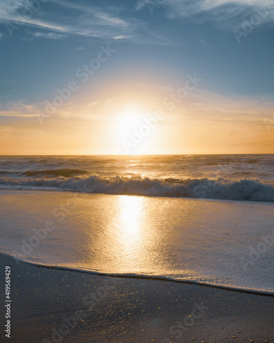 Golden sunset on the beach. Beautiful seascape in soft blue and yellow colors  relaxation  vacation concept  vertical banner