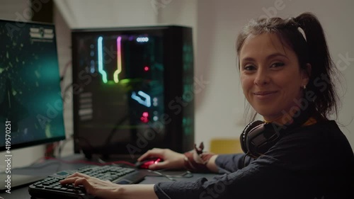 Concentrated gamer looking at camera while playing space shooter online video game on RGB powerful personal computer during egames championship. Esport cyber performing during gaming tournament photo