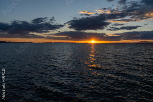 scenic and colorful sunset over the ocean with shimmering light on the waves