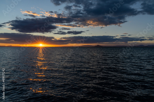 scenic and colorful sunset over the ocean with shimmering light on the waves