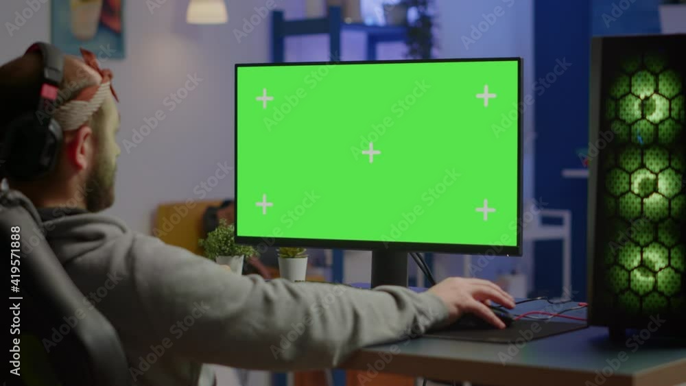 Gamer playing video games on powerful computer with green screen chroma ...