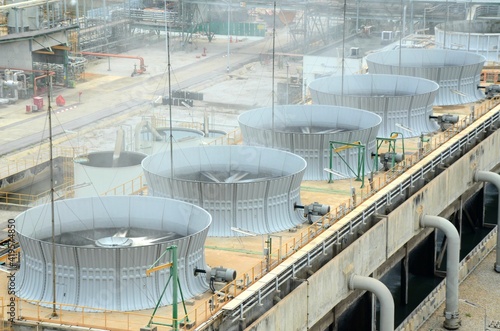 Cooling tower and cooling fan blowing steam on the air in chemical plant, refinery plant, oil and gas plant during operation.