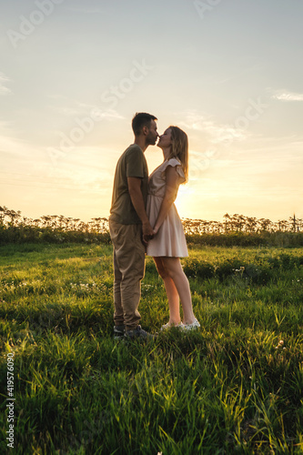 A couple in love in the field. Profile  sunset light.