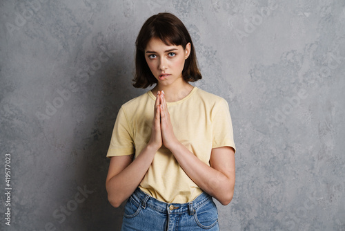 Portrait of a beautiful pleading young girl in casual clothes