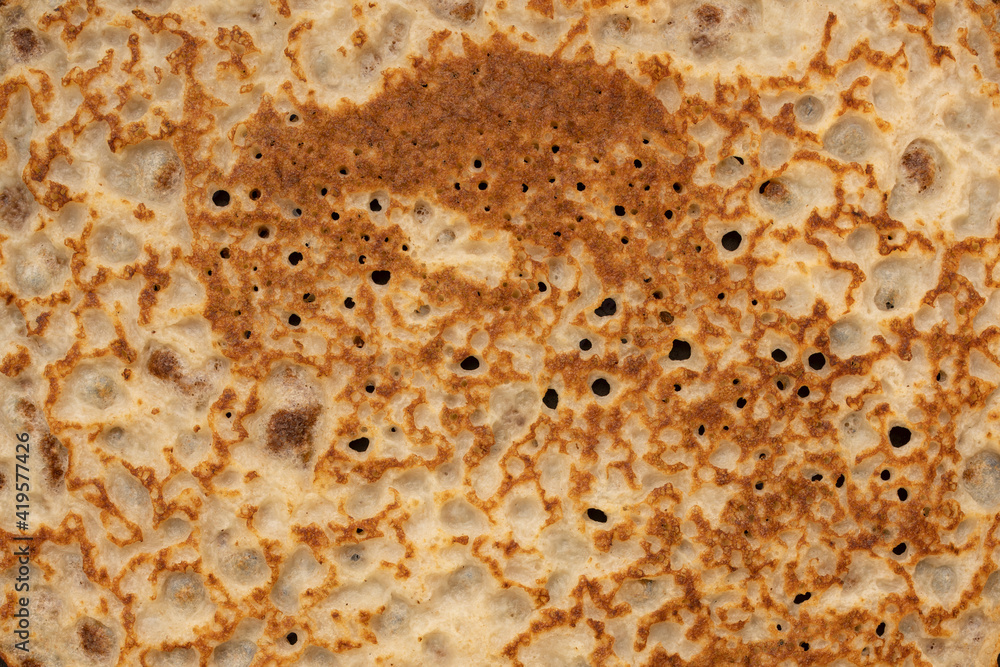 Pancake texture. Close-up of thin hot pancakes in a plate. Traditional rustic food. Folk cuisine. Table top view. Maslenitsa food. Pancake texture. Close-up of thin hot pancakes in a plate. Traditional rustic food. Folk cuisine. Table top view. Maslenitsa food.