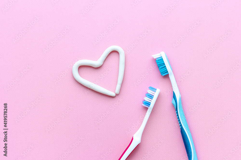 Teeth hygiene. Toothbrush with heart shape made of toothpaste, top view Teeth hygiene. Toothbrush with heart shape made of toothpaste, top view