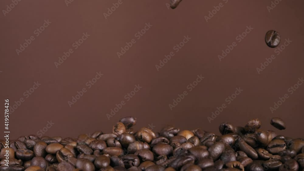 Flying coffee beans on a brown background. Super slow-motion. Flying coffee beans on a brown background. Super slow-motion.