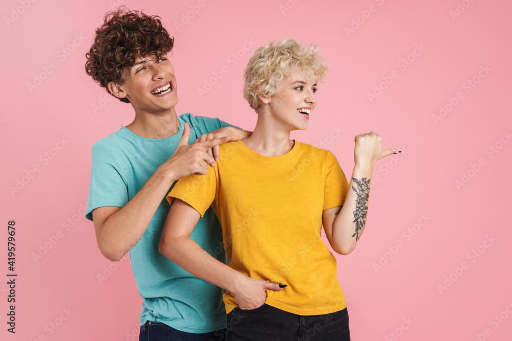 Cheerful young teenage couple poointing Cheerful young teenage couple poointing