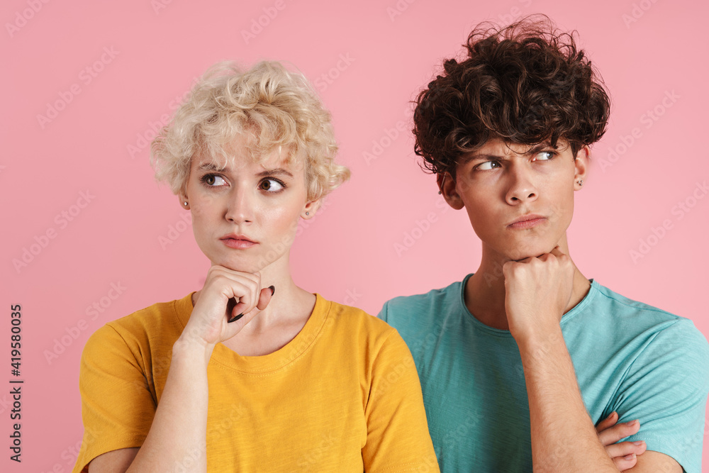 Portrait of a pensive teenage couple standing isolated Portrait of a pensive teenage couple standing isolated