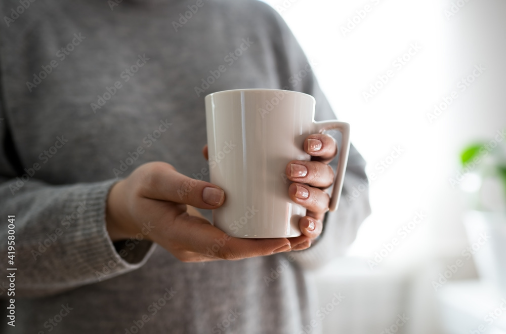 Close up of women's hands holding white mug with blank copy space scree for your advertising text message or promotional content, sweet coffee or tea. Close up of women's hands holding white mug with blank copy space scree for your advertising text message or promotional content, sweet coffee or tea.