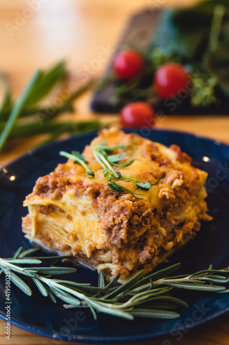 Piece of tasty hot lasagna with red wine. Selective focus