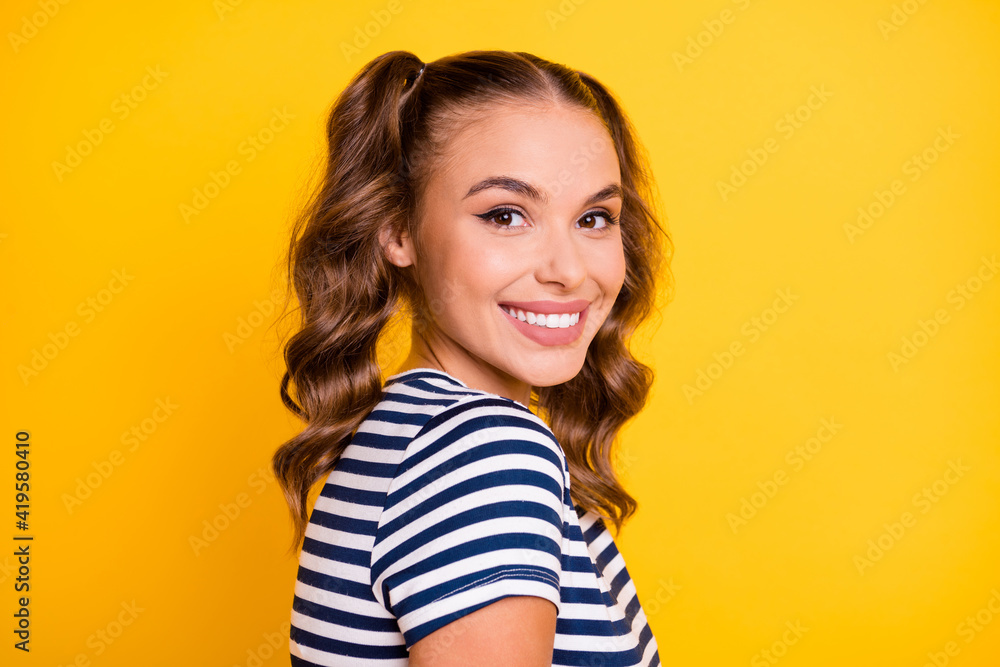 Profile side view portrait of attractive cheerful girl wearing summer tshirt isolated on bright yellow color background Profile side view portrait of attractive cheerful girl wearing summer tshirt isolated on bright yellow color background