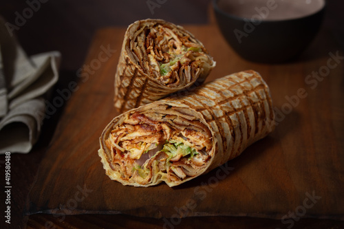 Photos Durum Kebab cut in two pieces on a wooden board