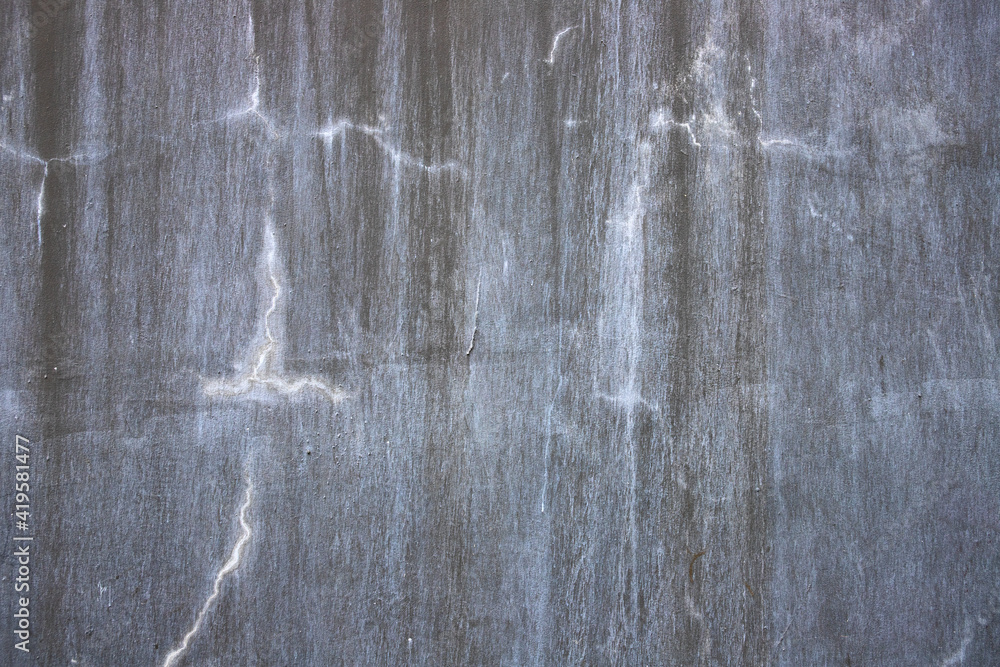 Obraz premium Concrete wall with grit and crack. Faded grey asphalt closeup. Cracked concrete surface top view. Old building wall abstraction. Natural material background for shabby design. Concrete wall texture