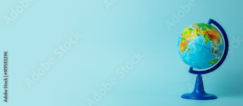 Earth globe on clean blue banner background. Education, school, study and knowledge background concept. photo