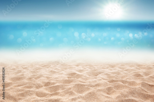 Tropical summer sandy beach focus area and bokeh sun light on blurry sea background Summer time concept background