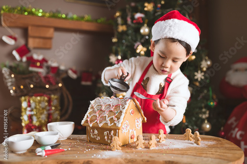 young girl making gingerbread house at home