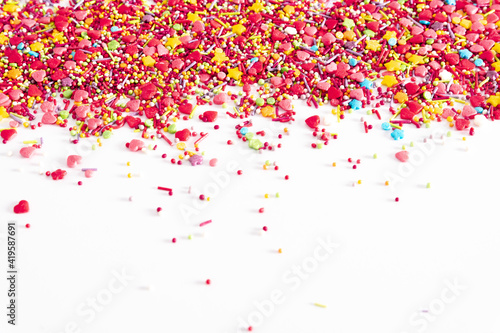 Sweet background. Colorful sprinkles sugar decoration for topping cake and bakery on white background.