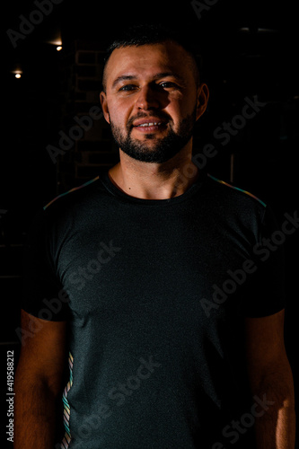 Smiley guy in black t-shirt, portrait. Portrait of handsome single bearded young man with serious expression wearing.