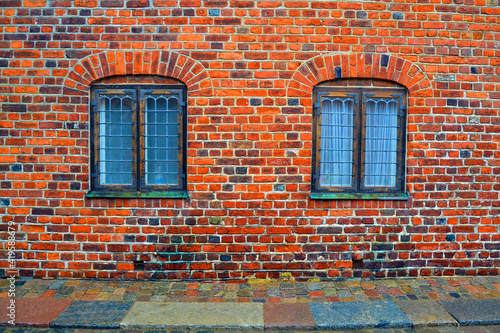 Old facade of the brick building with bars on the windows. Frederiksborg castle complex, Hillerod, Denmark