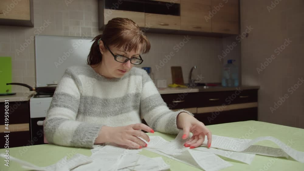 woman examines the purchases made and the prices at home, shopping spends a lot of money woman examines the purchases made and the prices at home, shopping spends a lot of money