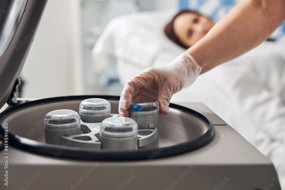 Female doctor hands using laboratory centrifuge in clinic Female doctor hands using laboratory centrifuge in clinic