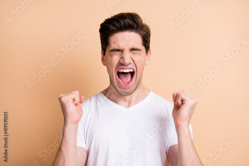 Quadro su tela Portrait of hooray brunet man yell hands fists wear white t-shirt isolated on be